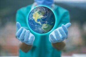 Person in scrubs holding photo of the world